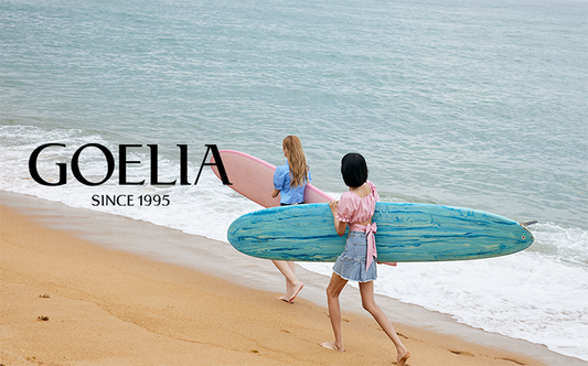 2 ladies holding surfboard