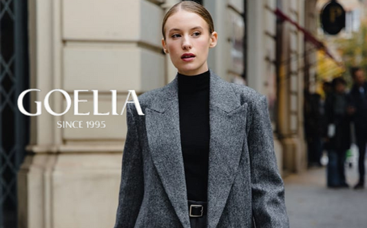 a lady in a black sweater, a pair of grey pants and a grey long wool coat