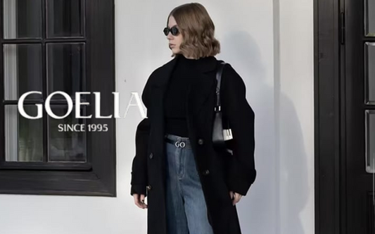 a lady in a black sweater, a black wool coat and a pair of wide leg jeans