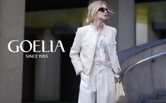 a lady in a white sheer blouse, a white tweed jacket and a pair of white jeans