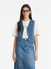 A lady wears a denim crop vest.