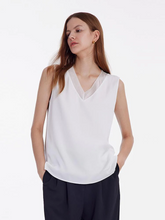 a lady in silk white v-neck sleeveless top
