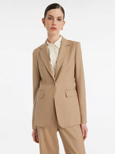 a lady in camel blazer with beige shirt and camel pants