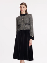 a lady in black tweed jacket with black midi velvet dress