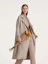 a lady in beige wool coat with beige cashmere top
