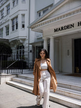 A lady wears a worsted wool trench coat.