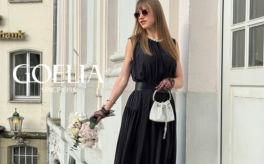 A girl with sunglasses wears a black silk dress