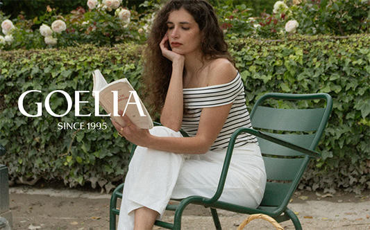 a lady wears a striped off-shoulder top with white pants 