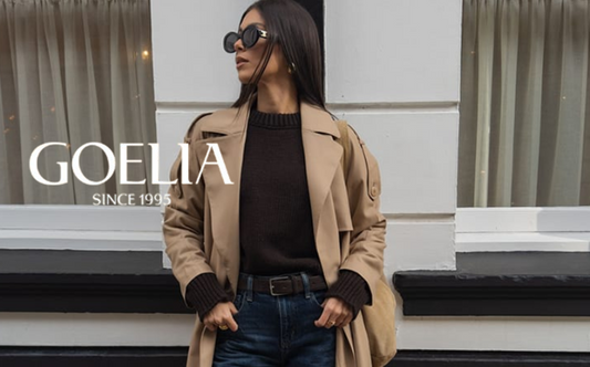 a lady in a black sweater, a long trench coat and a pair of jeans