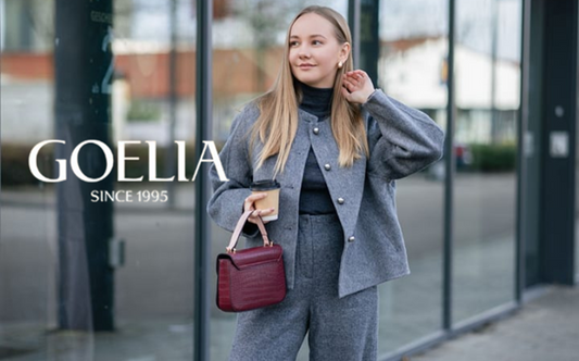 a lady in a black knit top, a grey wool jacket and a pair of grey wool pants