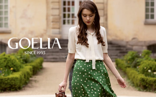 a lady in a white bow tie neck knit top and a green skirt with white polka dots