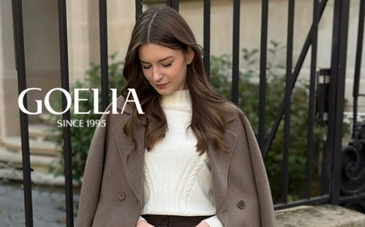 a lady in a white sweater, a black skirt and a grey wool coat