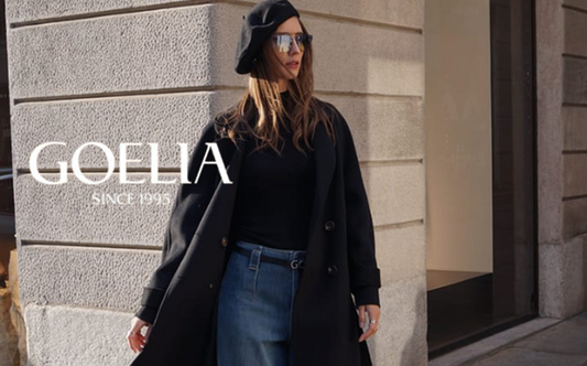 a lady in a black sweater, a black wool coat and a pair of wide leg jeans