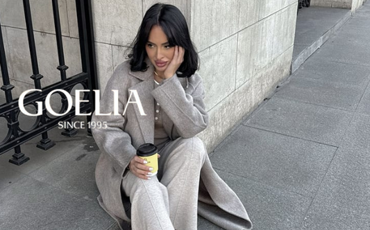 a lady in a brown top, a pair of beige wool pants and a grey wool coat