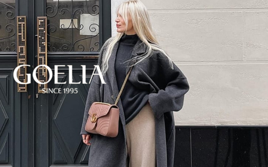 a lady in a black knit top, a grey wool coat and a pair of beige wide leg pants