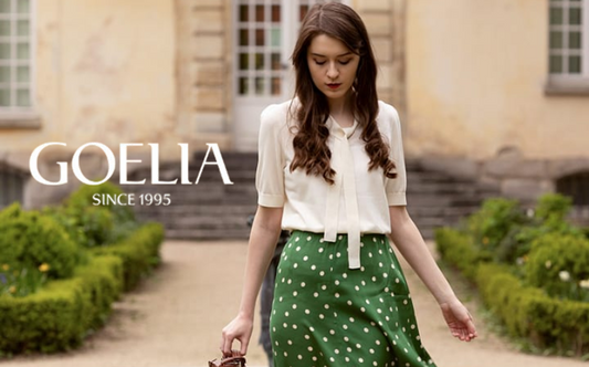 a lady in a white bow tie neck shirt and a green skirt with white polka dots
