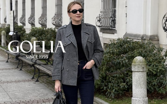 a lady in a black top, a pair of black flared jeans, a grey wool coat and a pair of boots