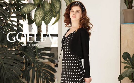 a lady in a black dress with polka dots and a black cardigan