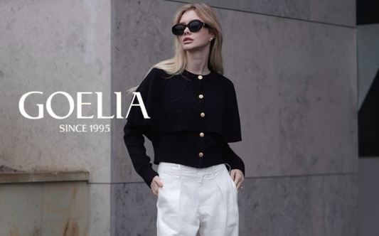 a lady in a black cardigan and a pair of white wide leg pants