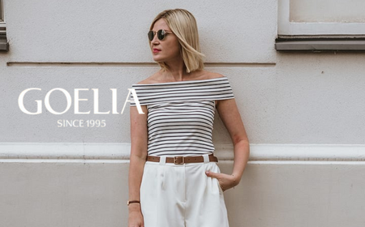 a lady in a black and white striped off shoulder top and a pair of white shorts
