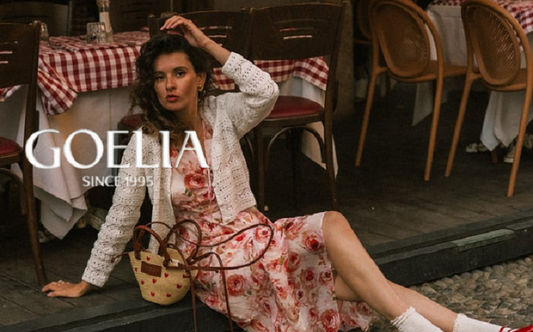a lady in a white openwork cardigan and a pink rose printed dress