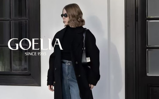 a lady in a black sweater, a black wool coat and a pair of wide leg jeans