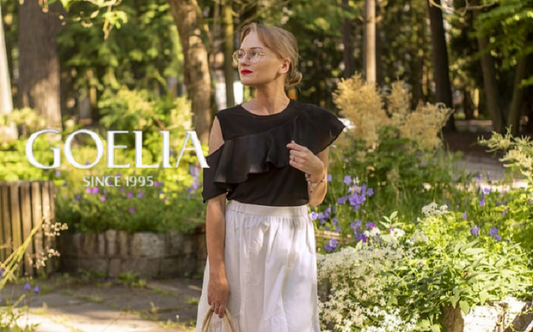 a lady in a black ruffle top and a white elastic skirt