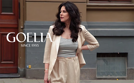 a lady in a striped cami and a camel blazer 