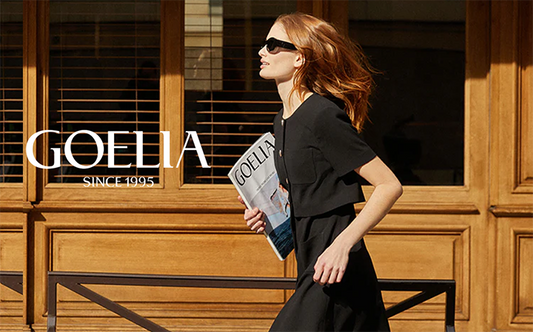 a lady in a mini black dress wearing black sunglasses 